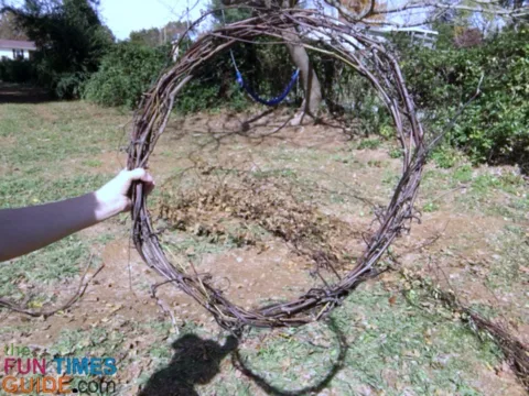 I started this DIY grapevine wreath by choosing the longest grapevine available and making a circle in the desired diameter.