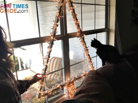 I wrapped some lights around a simple DIY Christmas tree frame to make a lighted window Christmas tree!