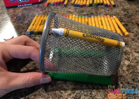 The first crayon glued onto the wire mesh pencil holder.